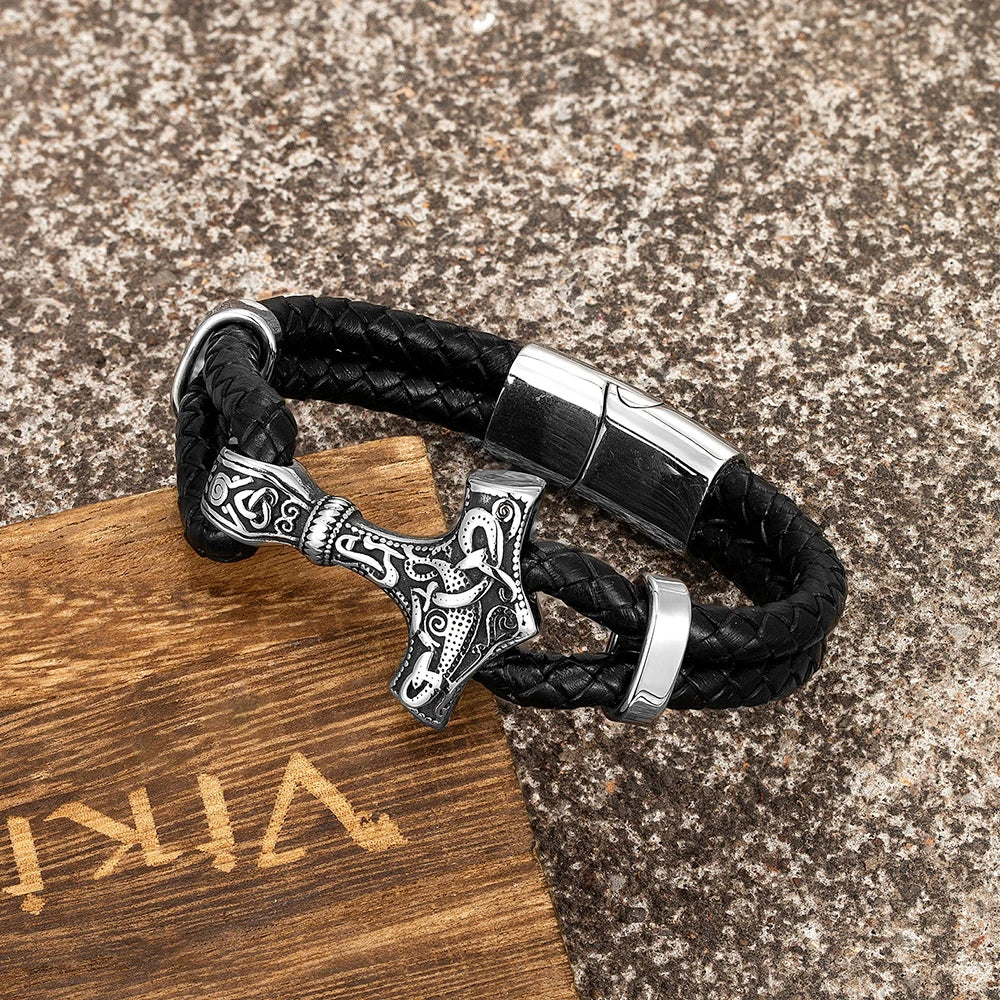 Bracelet de Thor in leather with a detailed silver Thor's hammer pendant, displayed on a textured surface.